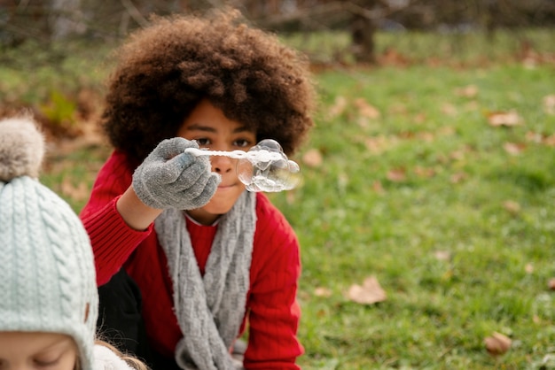 Kostenloses Foto nahaufnahme von kindern, die draußen seifenblasen machen