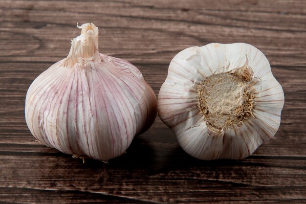 Nahaufnahme von Knoblauchknollen auf hölzernem Hintergrund