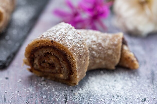 Nahaufnahme von köstlich aussehenden geschnittenen rohen veganen Brötchen auf einer lila Tischplatte