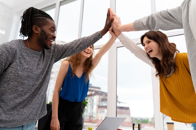 Kostenloses Foto nahaufnahme von kollegen high five bei der arbeit