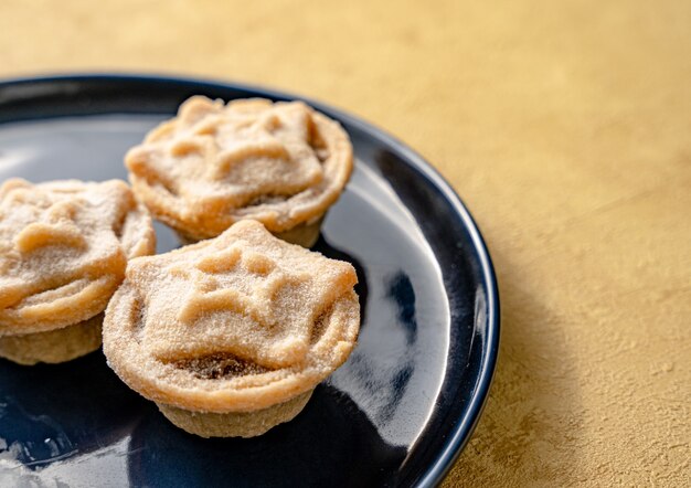 Nahaufnahme von leckeren sternförmigen Mince Pies, serviert auf einem Teller, einem traditionellen Weihnachtsdessert