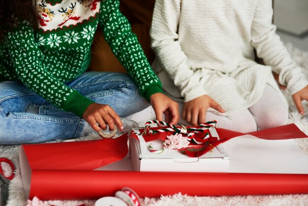 Nahaufnahme von Mädchen, die Geschenke für Weihnachten verpacken