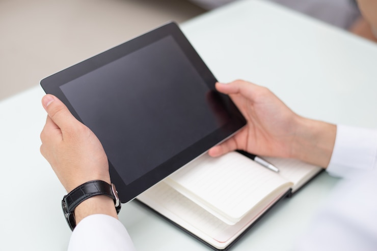 Kostenlose Foto nahaufnahme von männlichen händen unter verwendung der digitalen tablette im büro