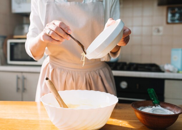 Nahaufnahme von mischenden Bestandteilen einer Frau für die Zubereitung der Torte