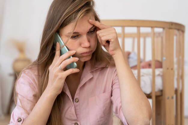 Nahaufnahme von müder Mutter, die am Telefon spricht