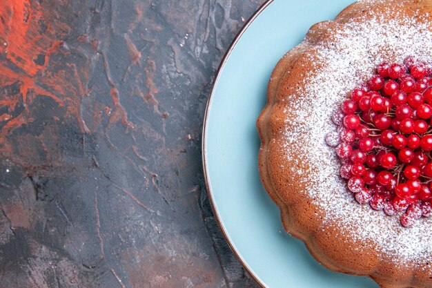 Nahaufnahme von oben ein appetitlicher Kuchen ein Kuchen mit roten Johannisbeeren auf dem blauen Teller