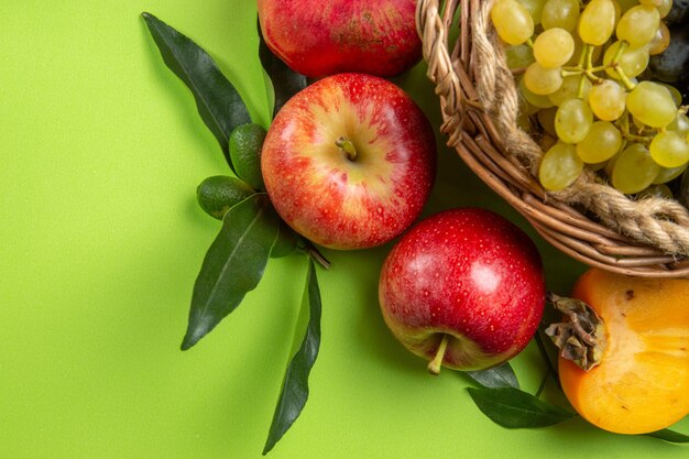 Nahaufnahme von oben Früchte Äpfel Granatäpfel Kaki Trauben und Blätter