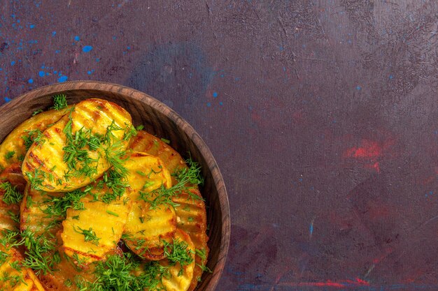 Nahaufnahme von oben leckere gekochte Kartoffeln mit Grüns im Teller auf dunkler Oberfläche kochen Kartoffel-Cips Abendessen