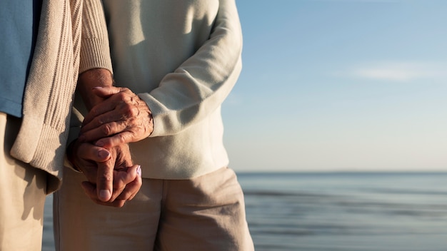 Nahaufnahme von Partnern, die Händchen am Meer halten