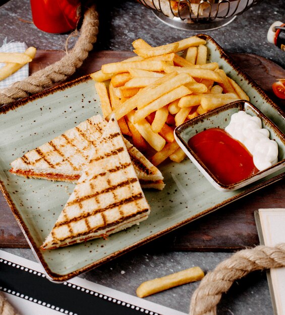 Nahaufnahme von Peperoni-Toast serviert mit Pommes und Saucen