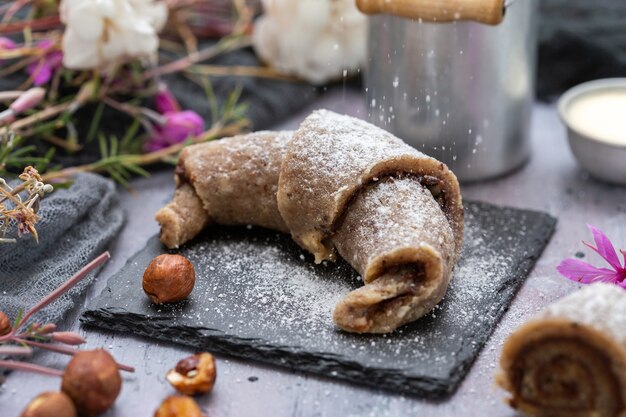 Nahaufnahme von rohen veganen Brötchen aus Haselnüssen auf einer lila Grunge-Tischplatte