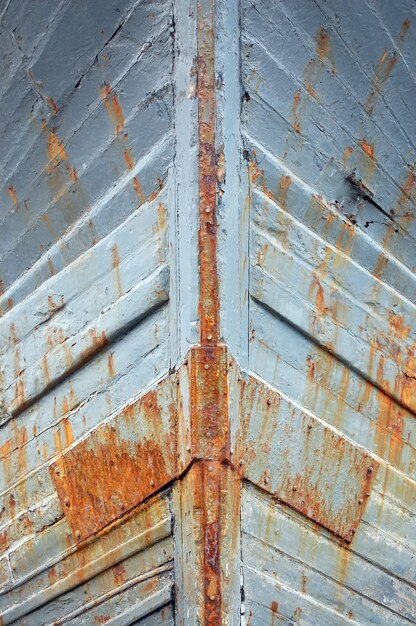 Nahaufnahme von rostigen eisernen Schiffswänden mit grauer Farbe darauf