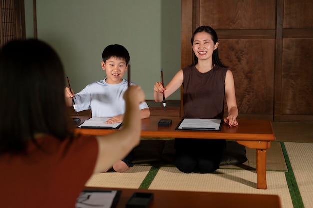 Nahaufnahme von Schülern, die japanische Kalligraphie machen, genannt Shodo