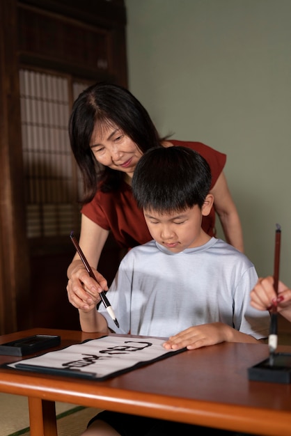 Nahaufnahme von Schülern, die japanische Kalligraphie machen, genannt Shodo