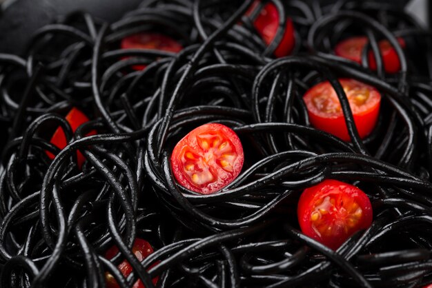 Nahaufnahme von schwarzen Spaghetti mit Tomaten
