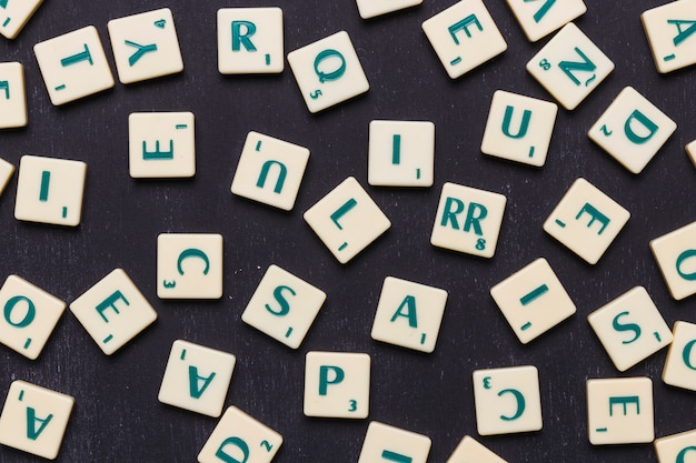 Nahaufnahme von Scrabble-Buchstaben gegen schwarzen Hintergrund