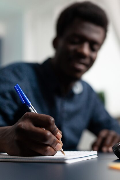 Nahaufnahme von Studenten, die Marketingstrategie auf Notebook schreiben