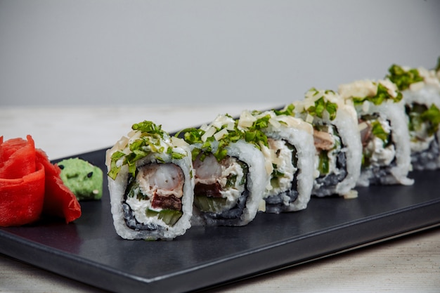 Nahaufnahme von sushi-rollen mit garnelen, frischkäse und gurke