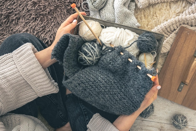 Kostenloses Foto nahaufnahme von weiblichen händen, die einen grauen wollpullover stricken