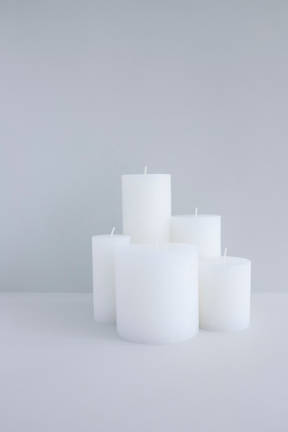 Nahaufnahme von weißen Kerzen gegen grauen Hintergrund