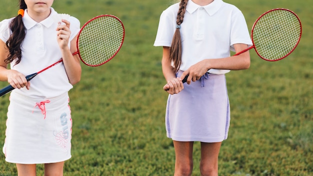 Nahaufnahme von zwei mädchen, die in der hand badminton halten