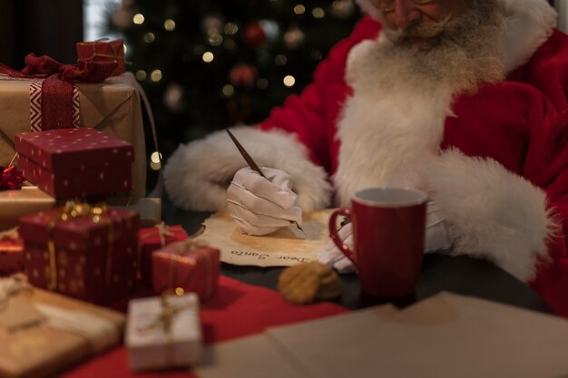 Nahaufnahme Weihnachtsmann, der einen Brief schreibt