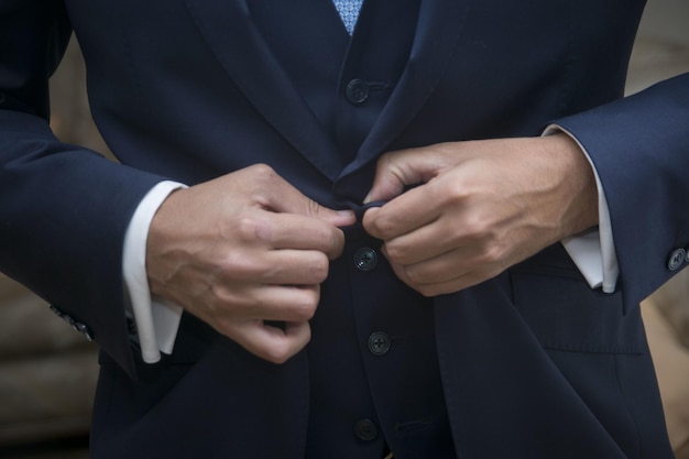 Nahaufnahmeaufnahme der Hände eines Geschäftsmannes in einem blauen Anzug