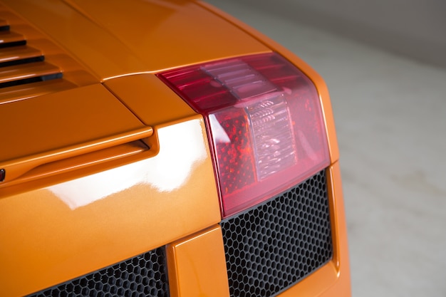 Nahaufnahmeaufnahme der hintergrundbeleuchtung eines modernen orangefarbenen autos