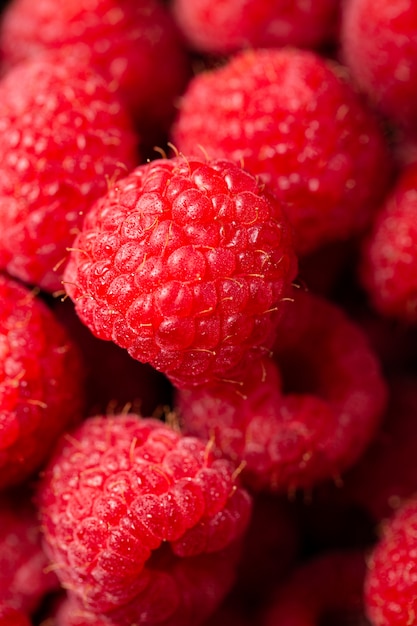 Nahaufnahmeaufnahme der niedlichen frischen Himbeeren aufeinander