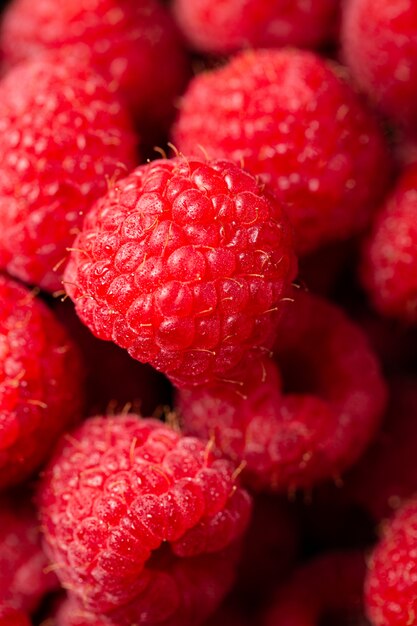 Nahaufnahmeaufnahme der niedlichen frischen Himbeeren aufeinander