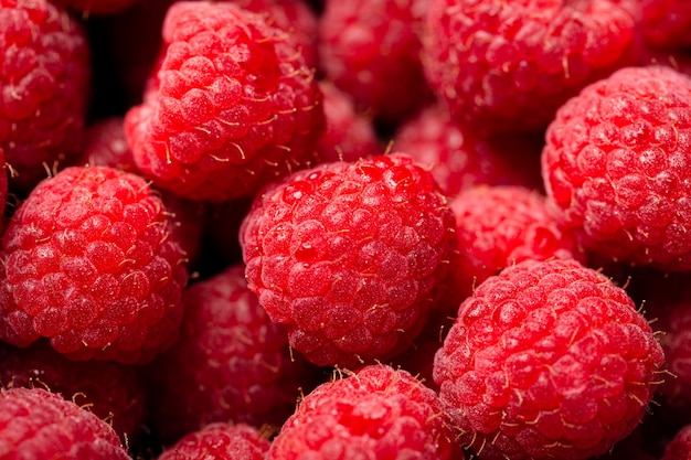 Nahaufnahmeaufnahme der niedlichen frischen Himbeeren aufeinander