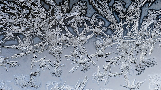 Nahaufnahmeaufnahme der schönen Frostmuster und der Texturen auf einem Glas