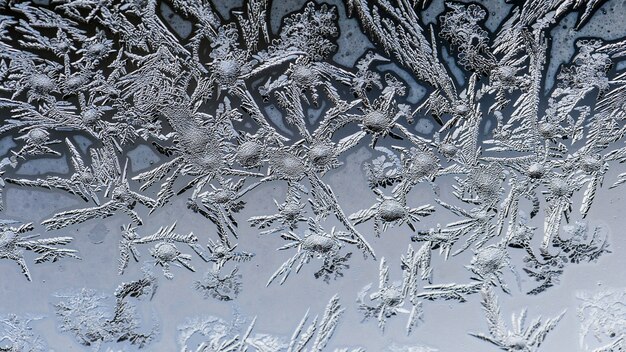 Nahaufnahmeaufnahme der schönen Frostmuster und der Texturen auf einem Glas