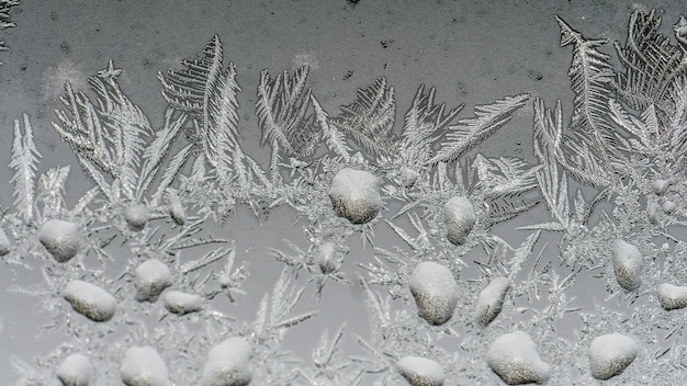 Nahaufnahmeaufnahme der schönen Frostmuster und der Texturen auf einem Glas