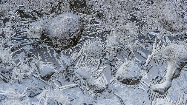Nahaufnahmeaufnahme der schönen Frostmuster und der Texturen auf einem Glas