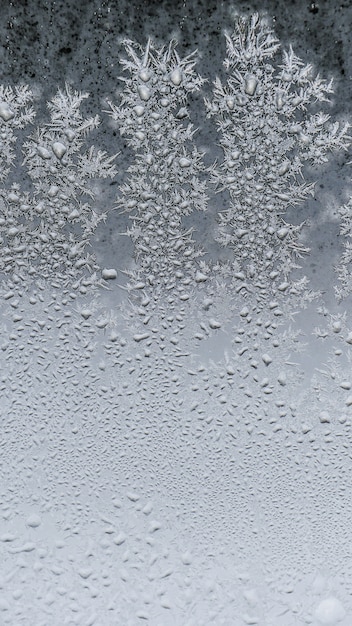 Nahaufnahmeaufnahme der schönen Frostschneeflockentextur auf einem Glas