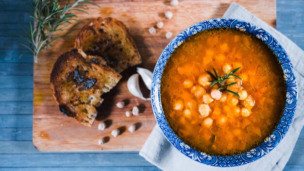 Nahaufnahmeaufnahme der traditionellen italienischen Kichererbsensuppe mit Rosmarin und Brot