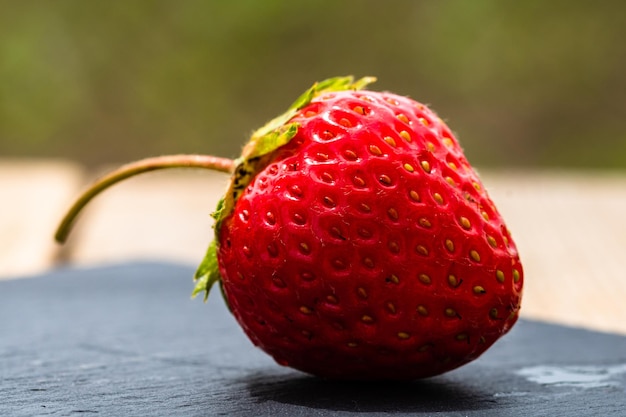 Nahaufnahmeaufnahme einer frischen Erdbeere auf einem unscharfen Hintergrund