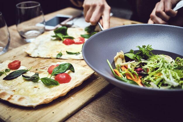 Nahaufnahmeaufnahme einer Person, die Gemüse schneidet und einen Salat macht