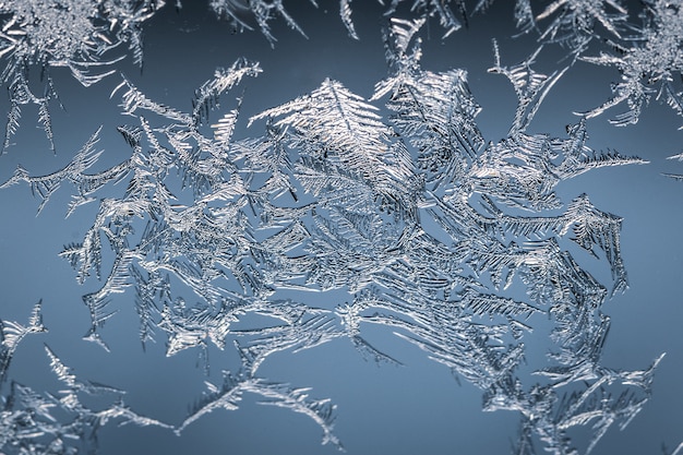 Nahaufnahmeaufnahme einer Schneeflocke auf einem Glas vom Frost, mit detailliertem Muster