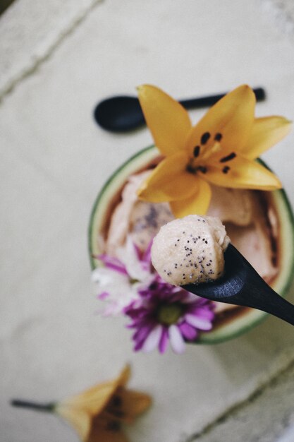 Nahaufnahmeaufnahme einer Schüssel Eiscreme mit schönen Blumendekorationen