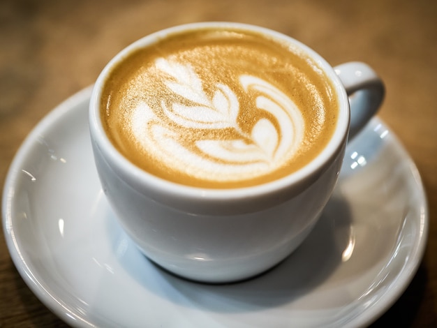 Nahaufnahmeaufnahme einer Tasse Cappuccino mit schöner Kaffeekunst