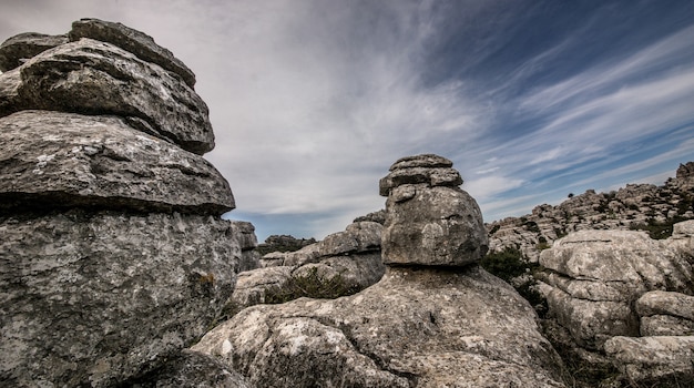 Nahaufnahmeaufnahme mehrerer grauer Felsen übereinander unter einem bewölkten Himmel