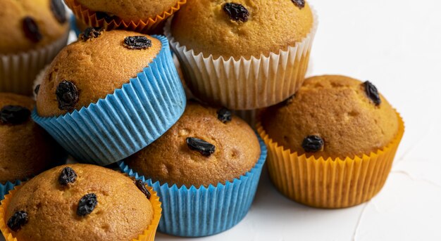 Nahaufnahmeaufnahme von Cupcakes mit orange und blauen Papieren auf einem weißen Hintergrund