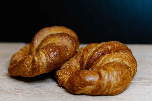 Nahaufnahmeaufnahme von frischen Croissants auf einer hölzernen Oberfläche