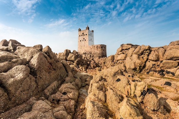 Nahaufnahmeaufnahme von Klippen und Felsen mit einer Festung auf dem Hintergrund unter einem blauen Himmel