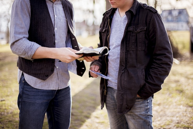 Kostenloses Foto nahaufnahmeaufnahme von zwei männern, die nahe beieinander stehen und die bibel lesen