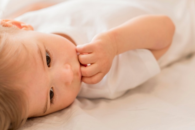 Nahaufnahmebaby, das im Bett sitzt