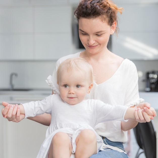 Nahaufnahmebaby, das mit Mutter zu Hause spielt