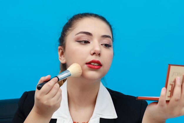 Nahaufnahmefoto der jungen schönen Dame, die Make-up anwendet